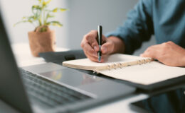 Homme avec un crayon écrivant dans le bloc-notes